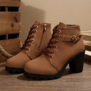 Detail view of brown combat boots with chunky heel and buckle strap