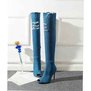 Detailed view of blue denim over-the-knee boots with peep toe and stiletto heels