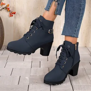 Detail view of navy blue lace-up combat boots with chunky heels and side zipper