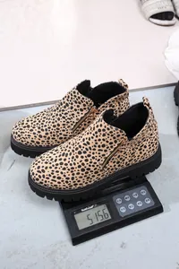 Detailed view of leopard print Chelsea boots showing weight on a digital scale.