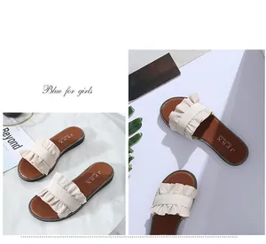Vue détaillée de la bride à volants beige élégante sur ces sandales plates d'été