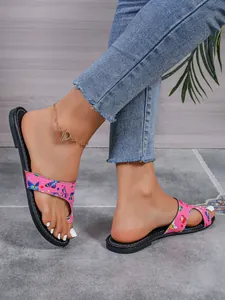 Detailopname van de platte damesslippers met vlinderprint en een teenlus ontwerp