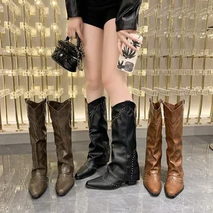 Detail view of stylish tall Western cowboy boots with rivets worn by an Asian model.