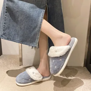Primo piano di accoglienti pantofole grigie in peluche con bordo in ecopelliccia bianca e stelle