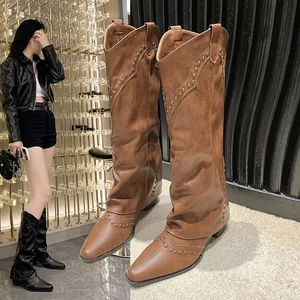 Detailed macro view of vintage studded brown Western cowboy knee-high boots for women