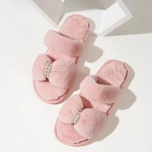 Dettaglio dei caldi sandali in pelliccia sintetica rosa con perle e strass eleganti.