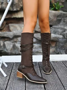 Detailed side view of brown tall knight boots with buckle straps and lace-up front