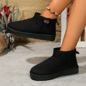 Close-up of black slip-on snow boots with warm lining and stylish red sport label detail.