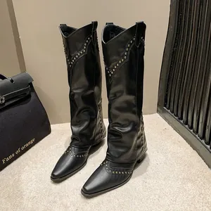 Detailed view of black retro western cowboy boots with gold rivets and pant-leg design