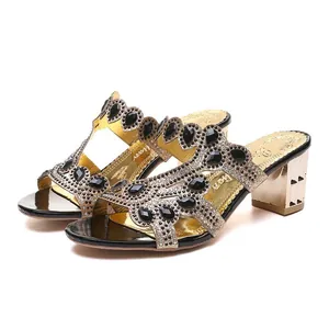 Elegant women's gold block heel sandals featuring intricate black rhinestone embellishments