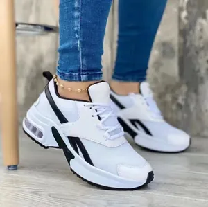 Close-up van witte mesh-sneakers voor dames met zwarte details en dikke zool