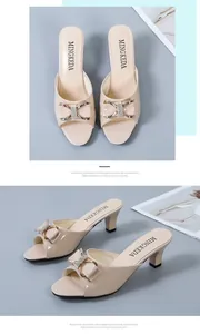 Detailansicht eleganter beigefarbener Pantoletten mit Absatz und Strass-Schleife.