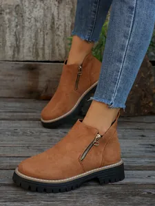 Close-up of tan suede ankle boots for women featuring a side zipper and chunky black lug sole.