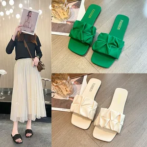 Sandalias planas de mujer con correas plisadas para las vacaciones de verano en la playa
