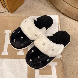 Primo piano di calde pantofole invernali in peluche da donna con strass a forma di stella