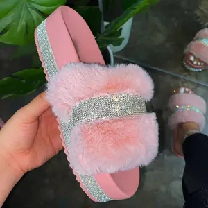 Close-up of pink faux fur platform slides with sparkly rhinestone bands for women