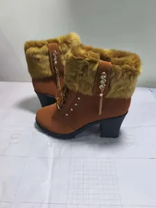 Side view of brown winter high heel boots featuring plush faux fur and rhinestone accents