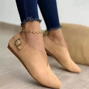 Detail view of beige suede V-cut flats featuring an elegant side buckle closure