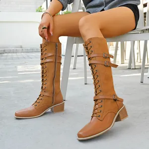 Detailed view of women's tan lace-up tall knight boots with buckles and block heel