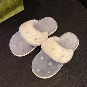 Dettaglio ravvicinato di pantofole invernali in peluche blu e bianche con stelle