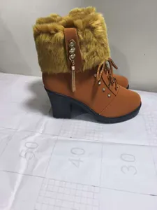 Detailed side view of brown block heel boots featuring faux fur collar and rhinestones