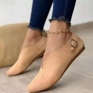 Detailed side view of elegant tan suede V-cut loafers featuring a stylish metal buckle