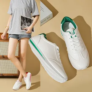 Detailed view of white casual sneakers with green accents in a lifestyle setting.