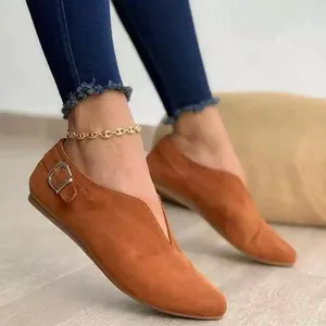 Detail view of brown suede flat shoes featuring a stylish V-cut vamp and side buckle