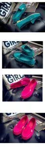 Detalle de mocasines de ante de colores con hebillas sobre fondo de cuero negro