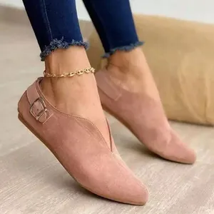 Close-up of pink suede V-neck flats with buckle detail and gold anklet accessory