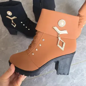 Detailed view of brown high-heel Martin boots with rhinestone and pearl pendant accents