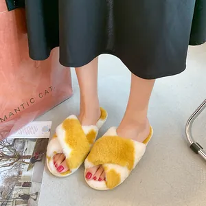 Primo piano di eleganti pantofole in peluche a incrocio gialle e bianche per casa