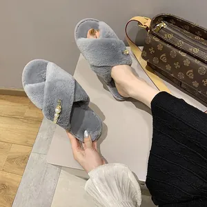 Détail de chaussons gris en fourrure à lanières croisées avec perles élégantes