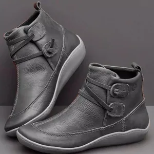 Detailed view of grey leather flat ankle boots with stylish button strap accents.