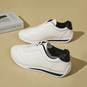 Detailed side view of white women's sneakers with black heel accents on tan background.