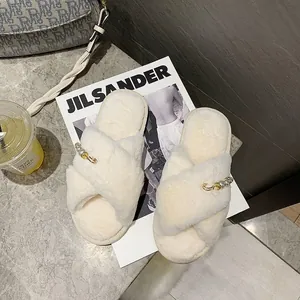 Vue détaillée des chaussons croisés en peluche crème avec breloque perle