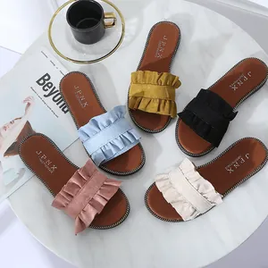 Sandales plates d'été pour femmes avec d'élégantes brides à volants en plusieurs couleurs.