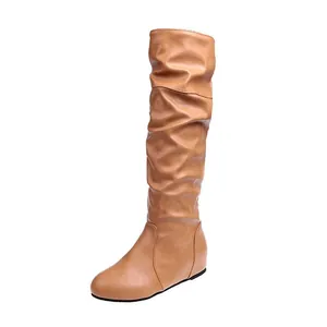 Close-up of tan slouchy mid-calf boots with pleated texture and round toe design