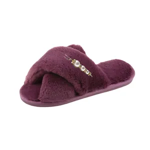 Vue détaillée de chaussons en fausse fourrure violette avec brides croisées et perles