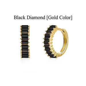 Detail of elegant gold-toned hoop earrings featuring channel-set black baguette stones