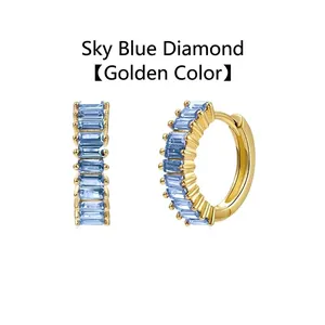 Detailed view of gold plated huggie hoop earrings featuring baguette-cut sky blue zircons