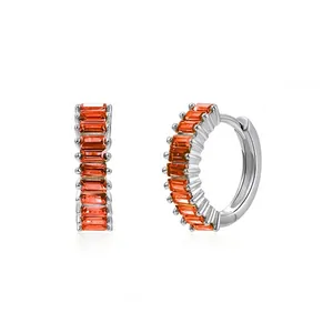 Detailed view of silver hoop earrings featuring vibrant orange baguette-cut zircon stones.