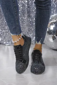 Close-up of stylish black glitter lace-up sneakers for women with shiny details