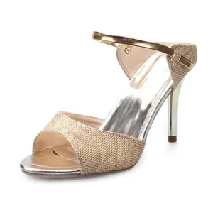Detailed view of golden glitter stiletto sandal with peep-toe and metallic strap