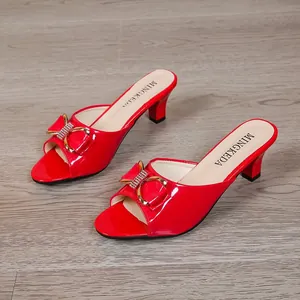 Elegante rote Lackleder-Sandalen mit mittlerem Absatz und stilvoller goldener Schleife.