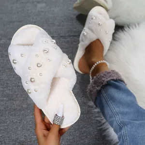 Elegant cream faux fur slippers featuring a stylish crossover design with pearl embellishments.