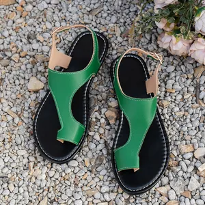 Flat toe-loop Roman sandals with green textured leather and soft black soles.