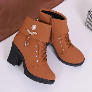 Detailed view of brown high-heeled boots with sparkling rhinestone and pearl accents.