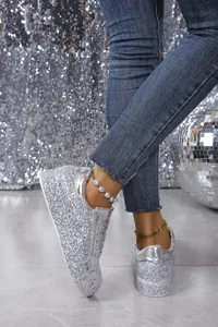 Close-up of silver glitter platform sneakers with metallic trim and lace-up design