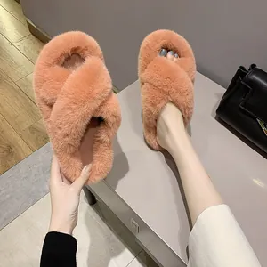 Cross-strap faux fur slippers for women in a warm coral pink for winter home wear.